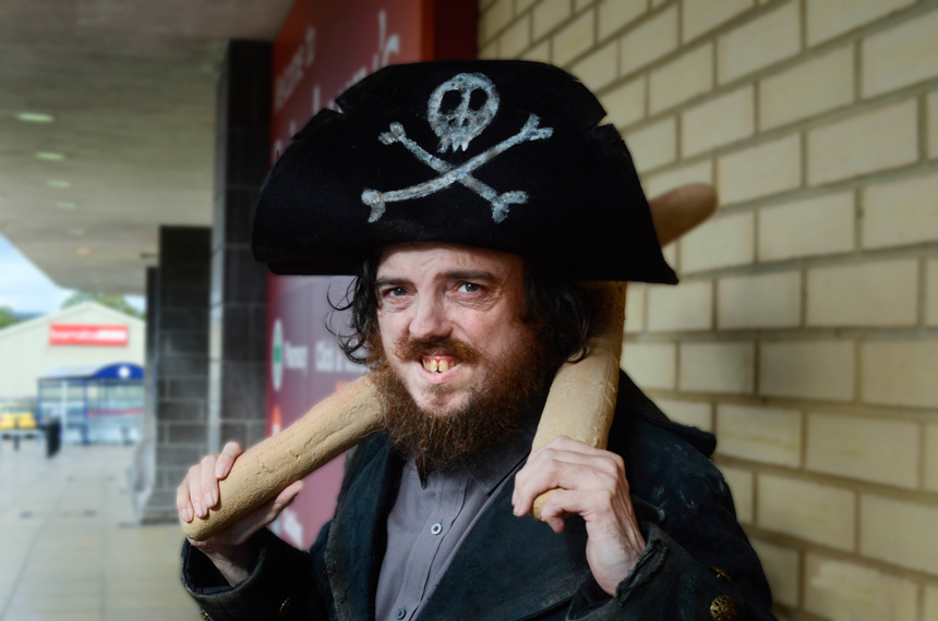 Picture of a man dressed as a pirate holding bread sticks