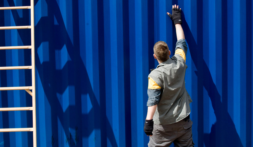 Picture of man standing by the container